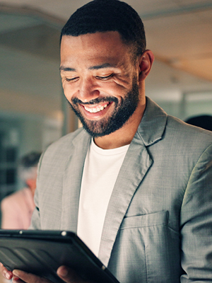 A gentleman smiling and looking at his tablet