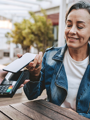 A lady using her phone to pay for her items