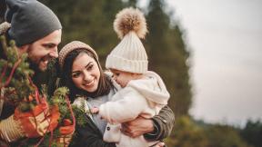 A mother and father with their daughter outside in nature. 